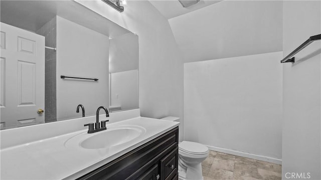 bathroom featuring vanity, toilet, and vaulted ceiling