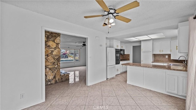 kitchen with sink, dark stone countertops, a textured ceiling, decorative backsplash, and white cabinets