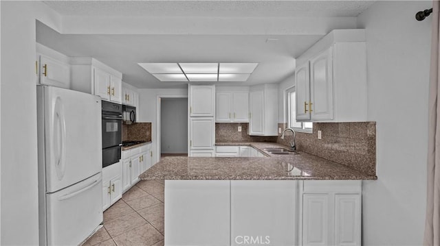 kitchen with white cabinetry, sink, tasteful backsplash, kitchen peninsula, and white fridge