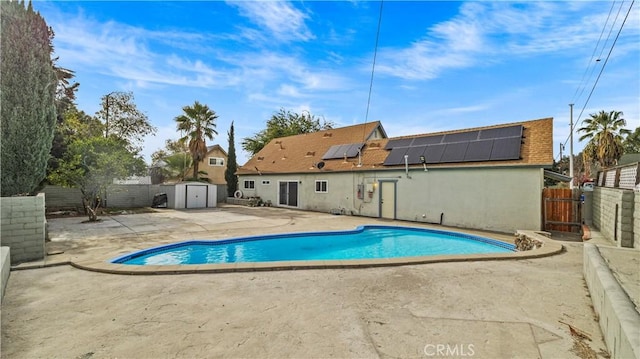 view of pool with a patio area and a storage shed