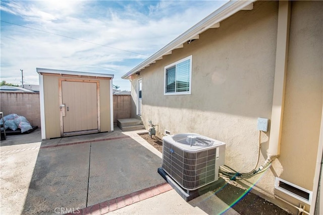 exterior space with cooling unit and a storage shed