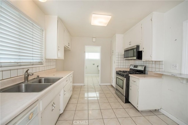 kitchen featuring decorative backsplash, white cabinetry, sink, and stainless steel appliances