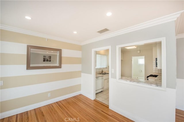 hall featuring sink, crown molding, and light hardwood / wood-style flooring