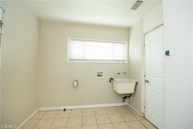 clothes washing area featuring washer hookup and light tile patterned floors