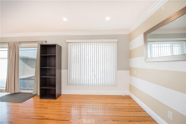 spare room featuring wood-type flooring and ornamental molding