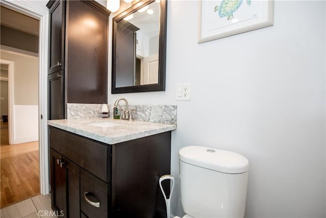 bathroom featuring vanity, hardwood / wood-style flooring, and toilet