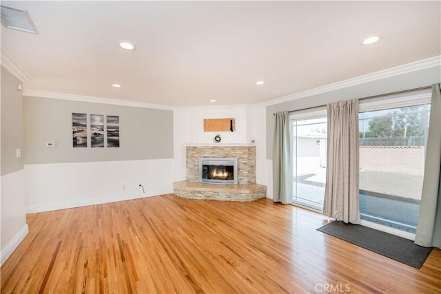 unfurnished living room featuring a stone fireplace, light wood-type flooring, and ornamental molding