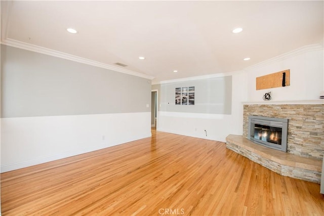 unfurnished living room featuring hardwood / wood-style flooring, ornamental molding, and a fireplace