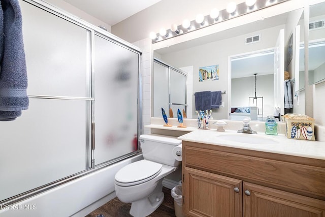 full bathroom featuring enclosed tub / shower combo, vanity, wood-type flooring, and toilet