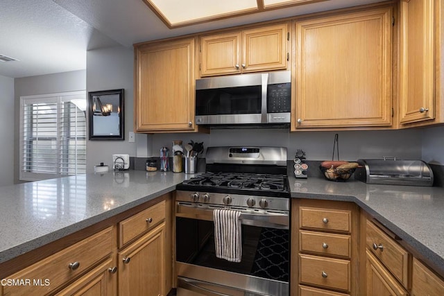 kitchen with appliances with stainless steel finishes and dark stone countertops