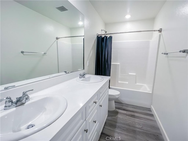 full bathroom with hardwood / wood-style floors, vanity, toilet, and shower / tub combo with curtain