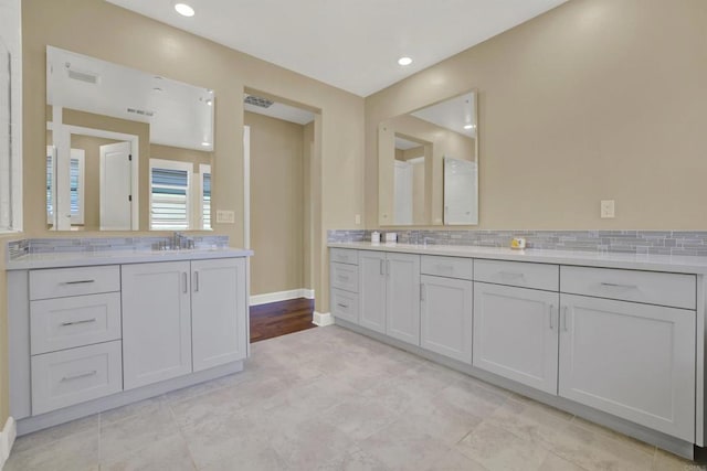 bathroom with vanity and tasteful backsplash