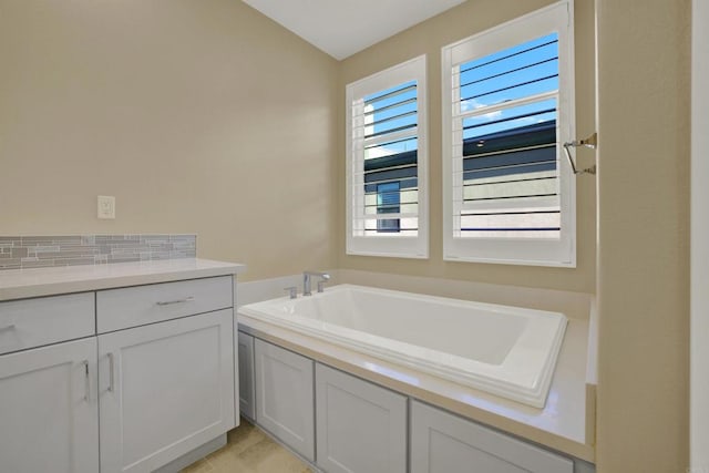 bathroom with tile patterned floors and a bath