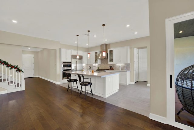 kitchen with stainless steel appliances, pendant lighting, white cabinetry, and a kitchen island