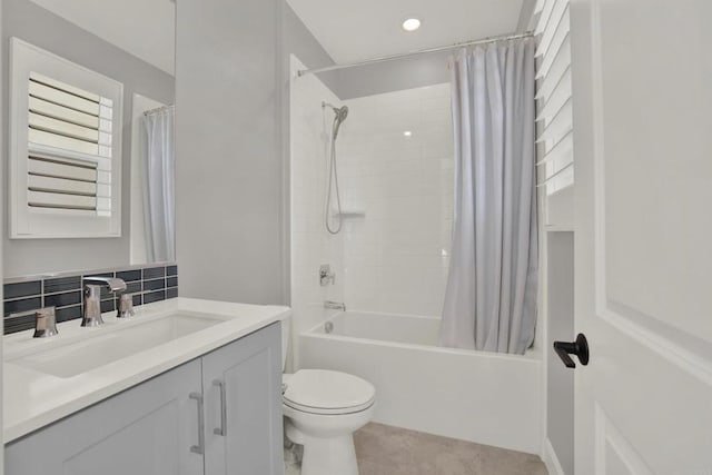 full bathroom featuring toilet, vanity, backsplash, tile patterned floors, and shower / bath combo