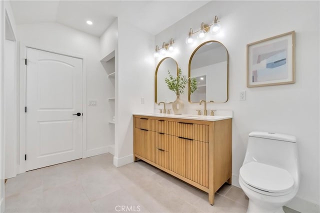 bathroom with tile patterned flooring, vanity, vaulted ceiling, and toilet