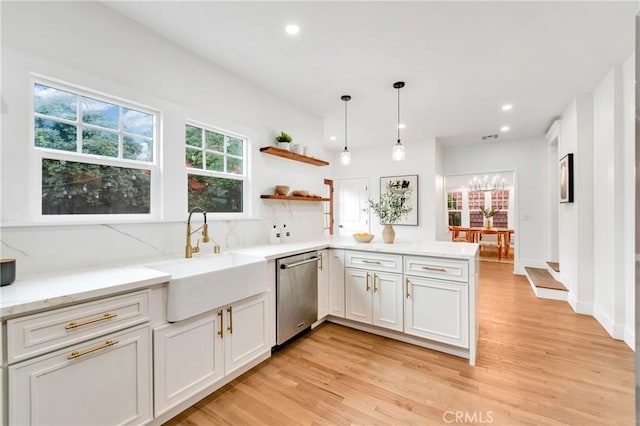 kitchen with light wood-type flooring, stainless steel dishwasher, plenty of natural light, and sink