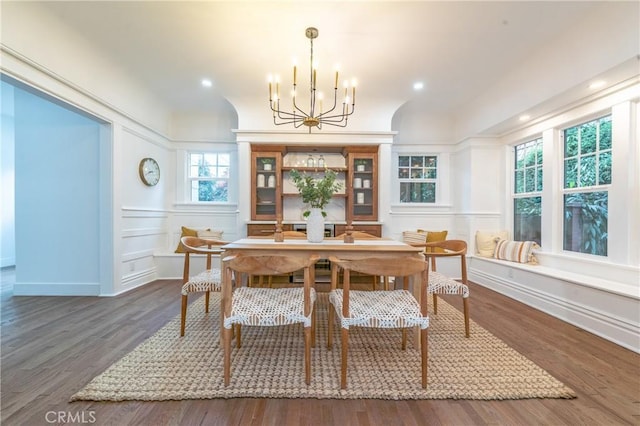 dining area featuring dark wood-type flooring and an inviting chandelier