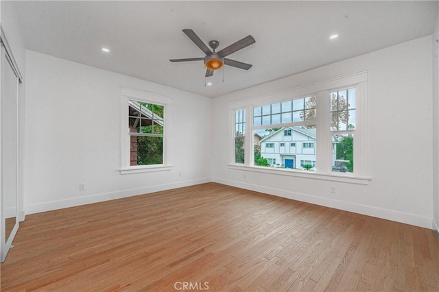 empty room with ceiling fan and light hardwood / wood-style floors