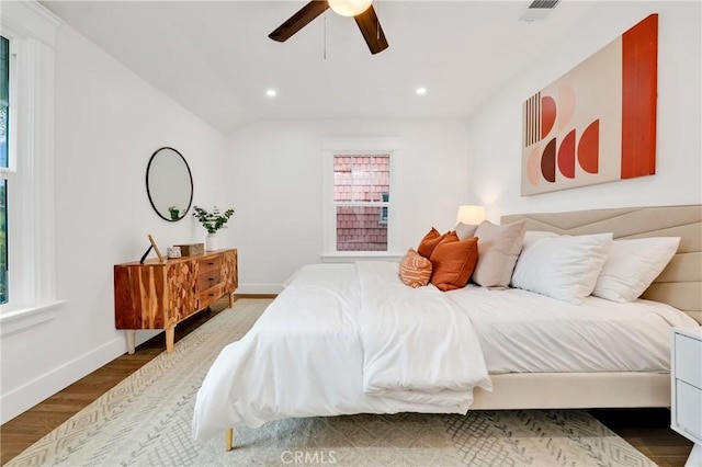 bedroom with hardwood / wood-style floors, vaulted ceiling, and ceiling fan