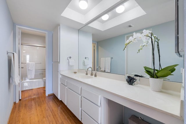 bathroom featuring tiled shower, vanity, and hardwood / wood-style flooring