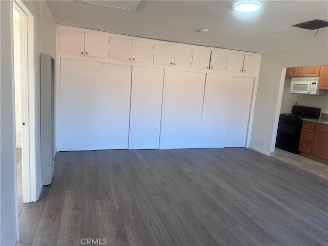 unfurnished bedroom featuring dark wood-type flooring and a closet