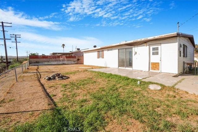 rear view of house featuring a yard and a patio