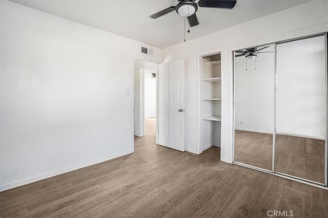 unfurnished bedroom with ceiling fan and wood-type flooring