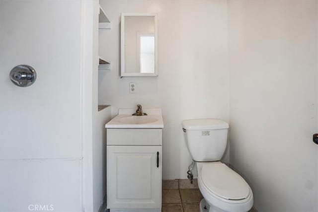 bathroom with tile patterned flooring, vanity, and toilet