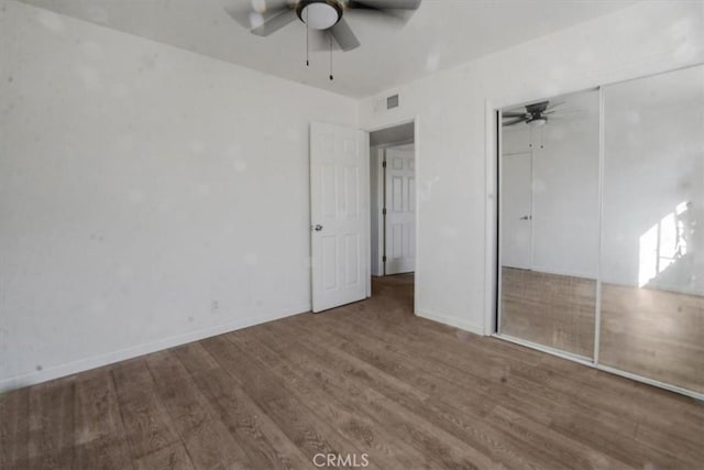 unfurnished bedroom with hardwood / wood-style floors, a closet, and ceiling fan