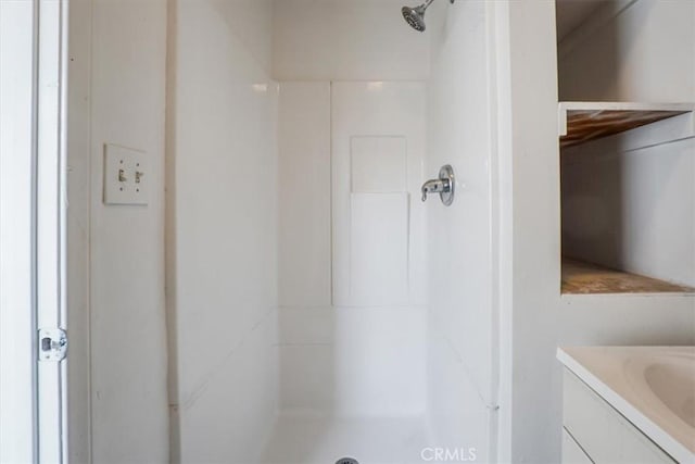 bathroom featuring a shower and vanity