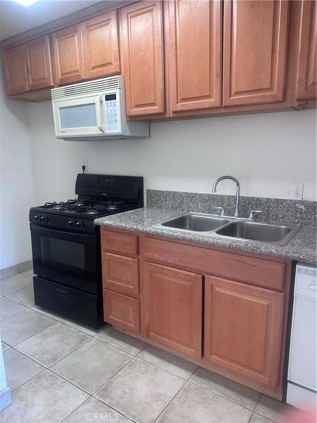 kitchen featuring sink, light tile patterned flooring, and white appliances