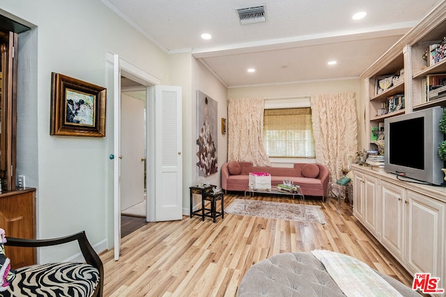 living room featuring light hardwood / wood-style floors and crown molding