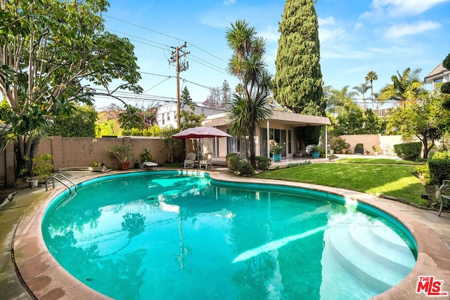 view of swimming pool with a yard and a patio