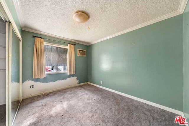 unfurnished bedroom with a textured ceiling, a wall mounted AC, crown molding, carpet floors, and a closet