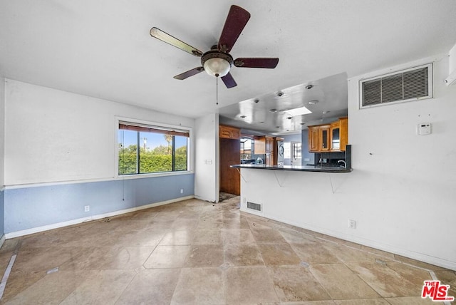 unfurnished living room with light tile patterned floors and ceiling fan