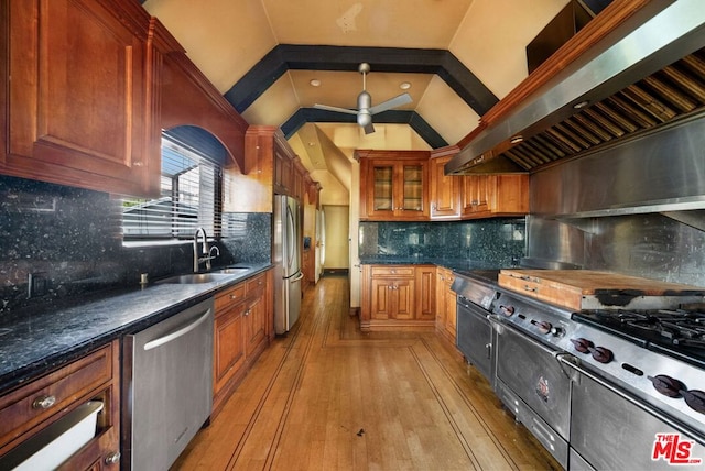 kitchen with sink, decorative backsplash, light hardwood / wood-style floors, stainless steel appliances, and extractor fan