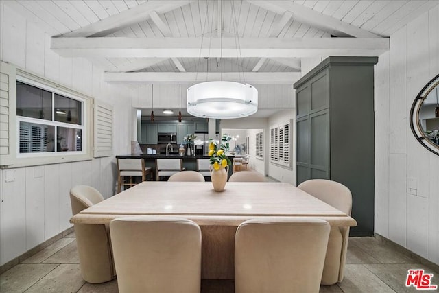 dining space with wood ceiling, wooden walls, and lofted ceiling with beams