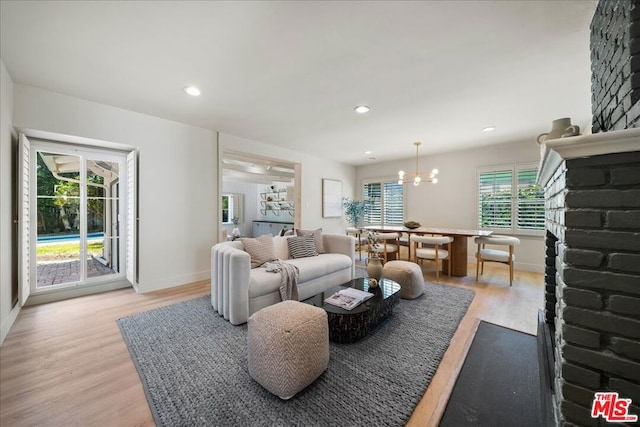 living room featuring light hardwood / wood-style floors and an inviting chandelier