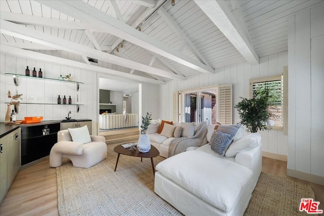 living room with a large fireplace, wood walls, and light wood-type flooring