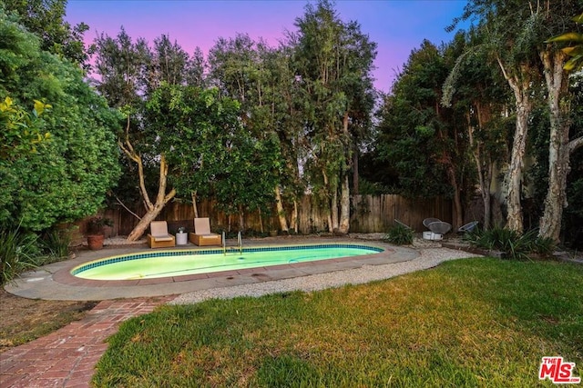 pool at dusk with a yard