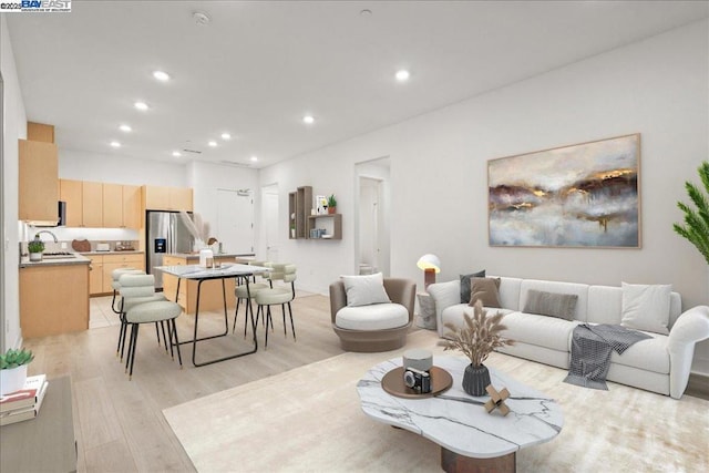 living room with sink and light hardwood / wood-style floors