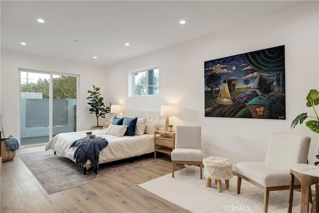 bedroom with access to outside, light hardwood / wood-style flooring, and multiple windows