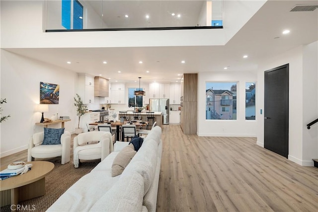 living room featuring a high ceiling and light hardwood / wood-style floors