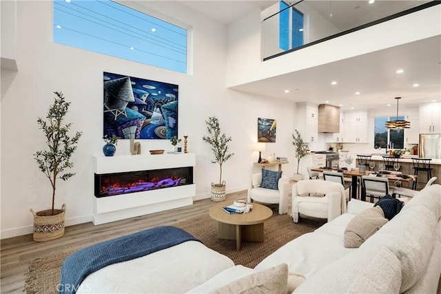 living room featuring hardwood / wood-style floors, a healthy amount of sunlight, and a high ceiling