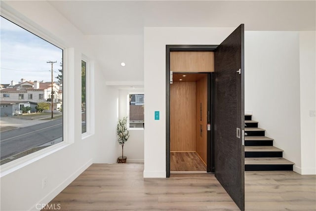 stairway featuring wood-type flooring and elevator