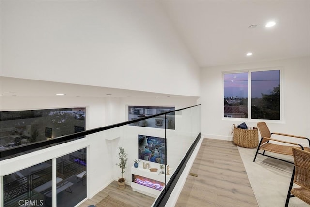 hall with hardwood / wood-style floors and vaulted ceiling