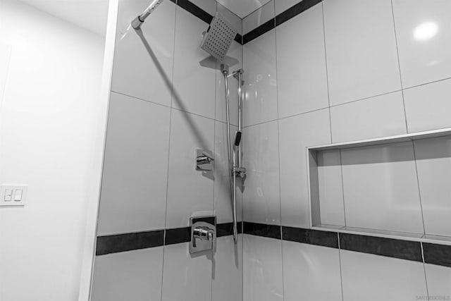 interior details featuring tiled shower