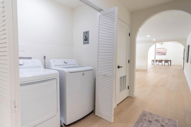 clothes washing area featuring light hardwood / wood-style floors and washing machine and clothes dryer