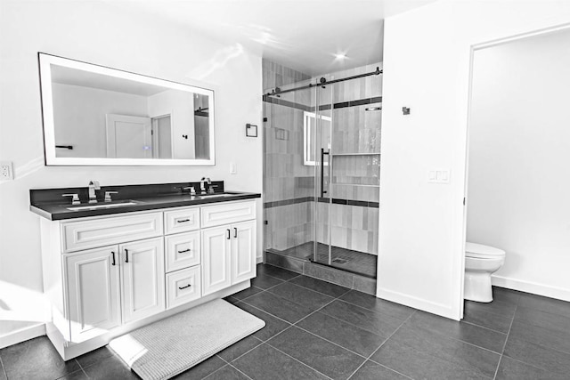 bathroom with toilet, a shower with shower door, tile patterned floors, and vanity